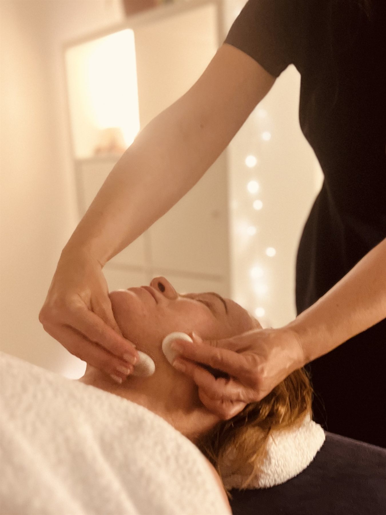 Cold marble stones used across the face and neck during a stone massage