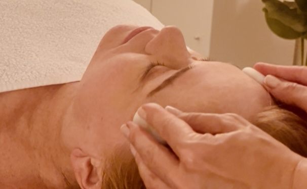 Detail of hands working across the forehead during a face massage