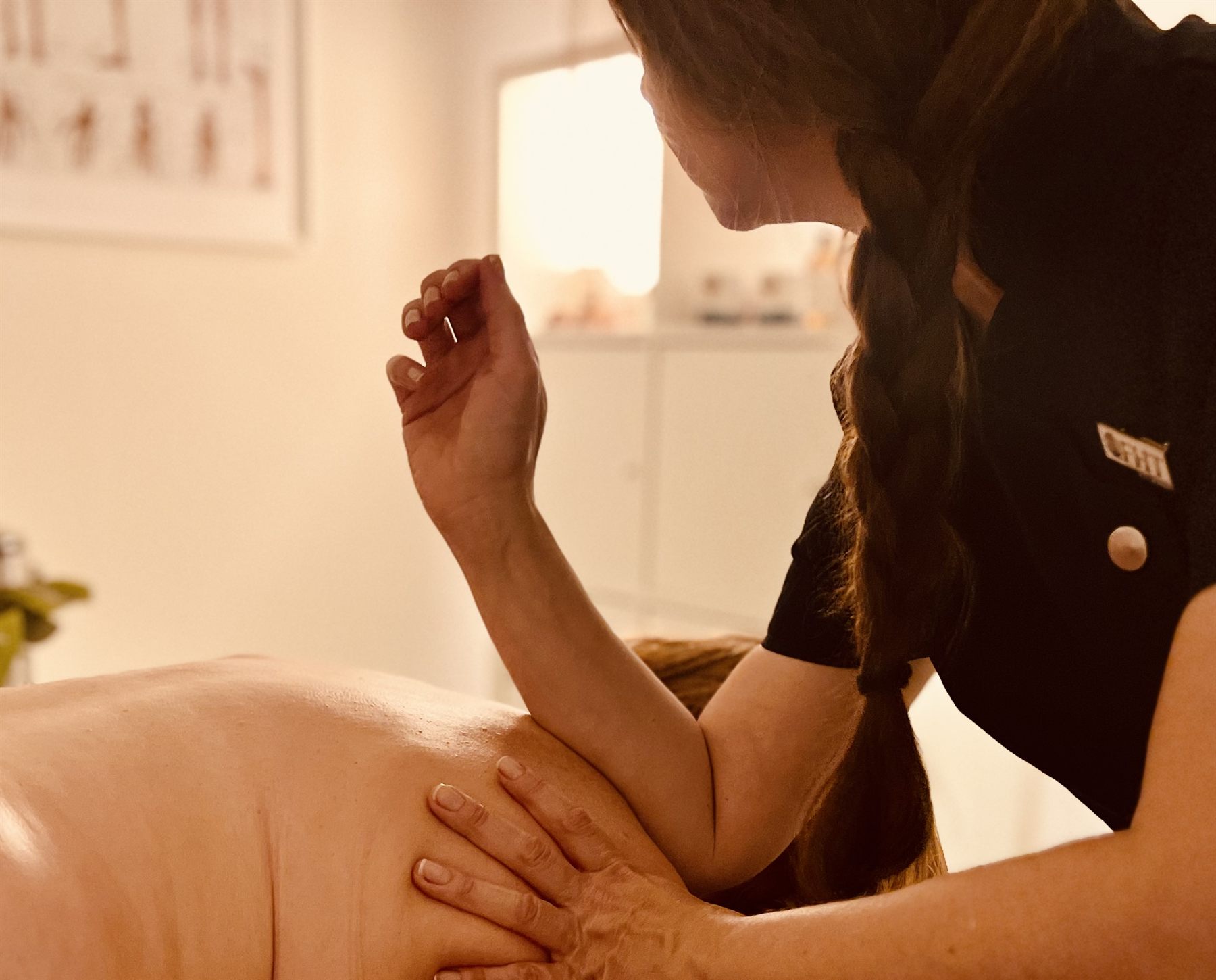 Swedish massage strokes being applied across the shoulders and upper back